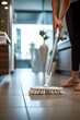 A woman is diligently cleaning the floor with a mop in a bathroom. She is focused on removing dirt and stains to make the tiles sparkle