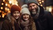 Happy family in winter clothes smiling and posing for a photo in front of a blurry background of Christmas lights.