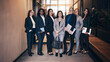 © Flamingo Images - Smiling group of diverse businesswomen standing in an office lobby. They are all wearing suits in different colors