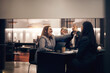 © Flamingo Images - Businesswomen laughing and high-fiving during a meeting in a hotel lobby
