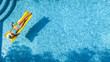 Beautiful woman in hat in swimming pool aerial drone view from above, young girl in bikini relaxes and swims on inflatable mattress and has fun in water on vacation, tropical holiday resort
