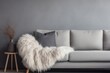 comfy sofa with gray furry sheepskin cover and pillows against the wall