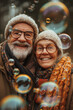 © Natasa - Joyful senior couple with soap bubbles in autumn park. Happy elderly couple enjoying a magical moment with colorful soap bubbles outdoors in fall.