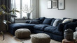Near the dark blue corner sofa are two knitted pouffes. Modern living room interior design in a Scandinavian home.