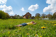 © somemeans - Child lies in grass in dandelions field and rejoices in sun. Summer vacation in the countryside. Sunny day