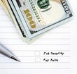 A pen and cash dollars money on lined note paper with checkbox choices to choose between  JOB SECURITIES and PAY RAISE - concept of making decision in career move