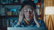 Asian young man is seen rubbing his tired eyes, feeling the strain from an extended period of working on a laptop computer