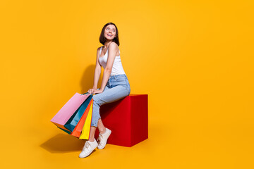 Sticker - Full length photo of funky dreamy woman wear white singlet holding bargains looking empty space isolated yellow color background