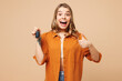 Young surprised woman she wears orange shirt casual clothes hold in hand car keys fob keyless system show thumb up isolated on plain pastel light beige background studio portrait. Lifestyle concept.