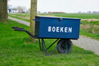 Dutch free mini public neighbourhood library where you can borrow and deliver books on a wheelbarrow with text boeken. This translates to books in english.