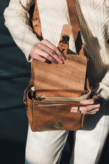 Poster - beautiful woman posing with a empty small brown bag near grey wall