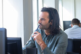 Fototapeta Morze - Portrait d'un bel homme de 30 ans qui travaille dans un bureau. il a les cheveux longs et une barbe