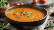 Vibrant autumn pumpkin soup garnished with herbs and spices
