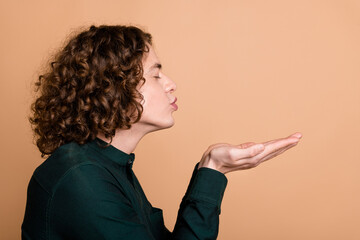 profile side photo of funny handsome young man wear green stylish clothes hold empty space send kiss