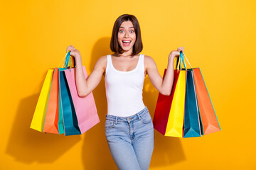 Canvas Print - Photo portrait of attractive young girl hold excited shopping bags wear trendy white outfit isolated on yellow color background