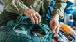 Hands meticulously preparing a backpack, filling it with necessary items for a trip to the hospital, highlighting the importance of preparation