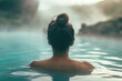 Beautiful young woman relaxing in hot springs pool in Iceland. Female traveler enjoying thermal bath in hot springs in Iceland.