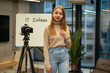 Russian teenage lady standing elegant, camera tripod whiteboard showing a presentation for a school project