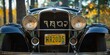 License plate on a vintage roadster, close-up, stories and miles behind