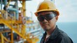 Asian petroleum engineer Inspect crude oil drilling rigs and industrial pipelines in a large factory behind an upstream subsea crude oil and gas production facility.
