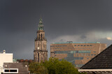 Fototapeta Las - The Martinitoren and the Forum building under a dark sky in the historical city centre of Groningen.