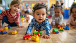 © Renata Hamuda - Group of Adorable Babies Playing Together with Colorful Toys on a Playroom Floor in the kindergarten