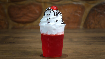 Wall Mural - Close-up shot of delicious jelly dessert garnished with nougat and cherry on a glass cup