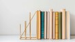 A set of geometric metal bookends, holding a row of colorful hardback books, set against a light, airy backdrop, emphasizing modern design and the love of reading low texture