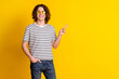 Photo of nice young man indicate finger empty space wear striped t-shirt isolated on yellow color background