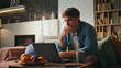 © stockbusters - Busy programmer working laptop at home late evening. Freelancer surfing internet