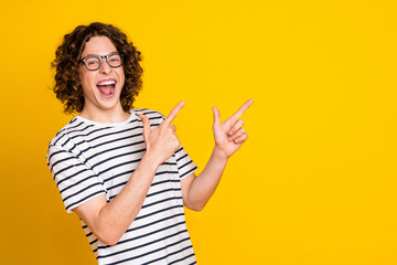 Sticker - Portrait of overjoyed crazy young positive guy directing empty space announce new opening courses isolated on yellow color background