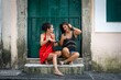 © Wirestock - Selective of two females wearing carnival masks against a door