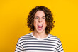 Portrait of young screaming mad furious aggressive guy wearing striped t shirt shouting open mouth isolated on yellow color background