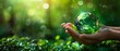 World Earth Day Concept of hands holding green earth on green bokeh background, saving environment, saving earth. World Earth Day Concept: green earth with hands holding green earth on green bokeh
