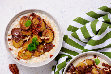 Wall Mural - Oatmeal with caramel bananas and chocolate in to the bowl