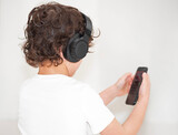 Fototapeta  - A young boy with headphones and a mobile phone in hand