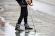 Woman walking with crutch on a city street, female legs on road. Leg injury, fracture or sprain