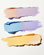 Samples of oval cream corrector in yellow, blue, lilac, pink for the face on a light background