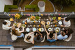 © Maskot - Directly above view of male and female friends having food while sitting at dining table during dinner party in balcony
