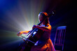 Talented young woman, cellist immersed in music, with striking halo of stage lights accentuating her silhouette on stage. Concept of hobby and work, music festivals, concerts, symphony show, culture.