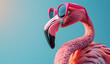 Pink  flamingo wearing pink glasses on turquoise background with copy space for text