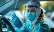 Medical professional in protective gear collects samples using a swab from a driver inside a vehicle