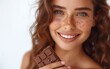 Joyful young lady indulging in chocolate, radiating beauty and happiness with each blissful bite