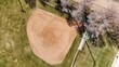 Aerial-Top down-Turning over empty softball diamond in the early spring with bare trees