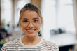 © Daria - Portrait of young female manager in eyeglasses standing on office background and looks camera