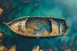 An aerial view of an old, rusty boat lying still in serene, clear blue waters, surrounded by rocks
