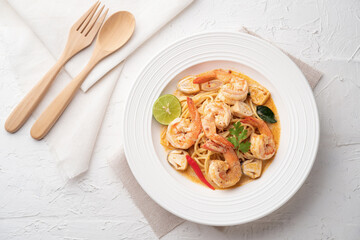 Wall Mural - Stir fried Spaghetti with Shrimp,squid and straw mushroom in tom yum sauce.Thai fusion food