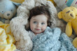Dreamy baby wrapped in a soft lavender blue pastel blanket, surrounded by a bunch of plush, sunny yellow stuffed animals and pillows in a crib.
