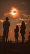 Silhouettes of people watching a solar eclipse at sunset