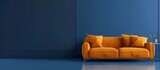 Fototapeta Przestrzenne - Photo of An orange sofa against an empty blue wall background. Web banner with copyspace on the right